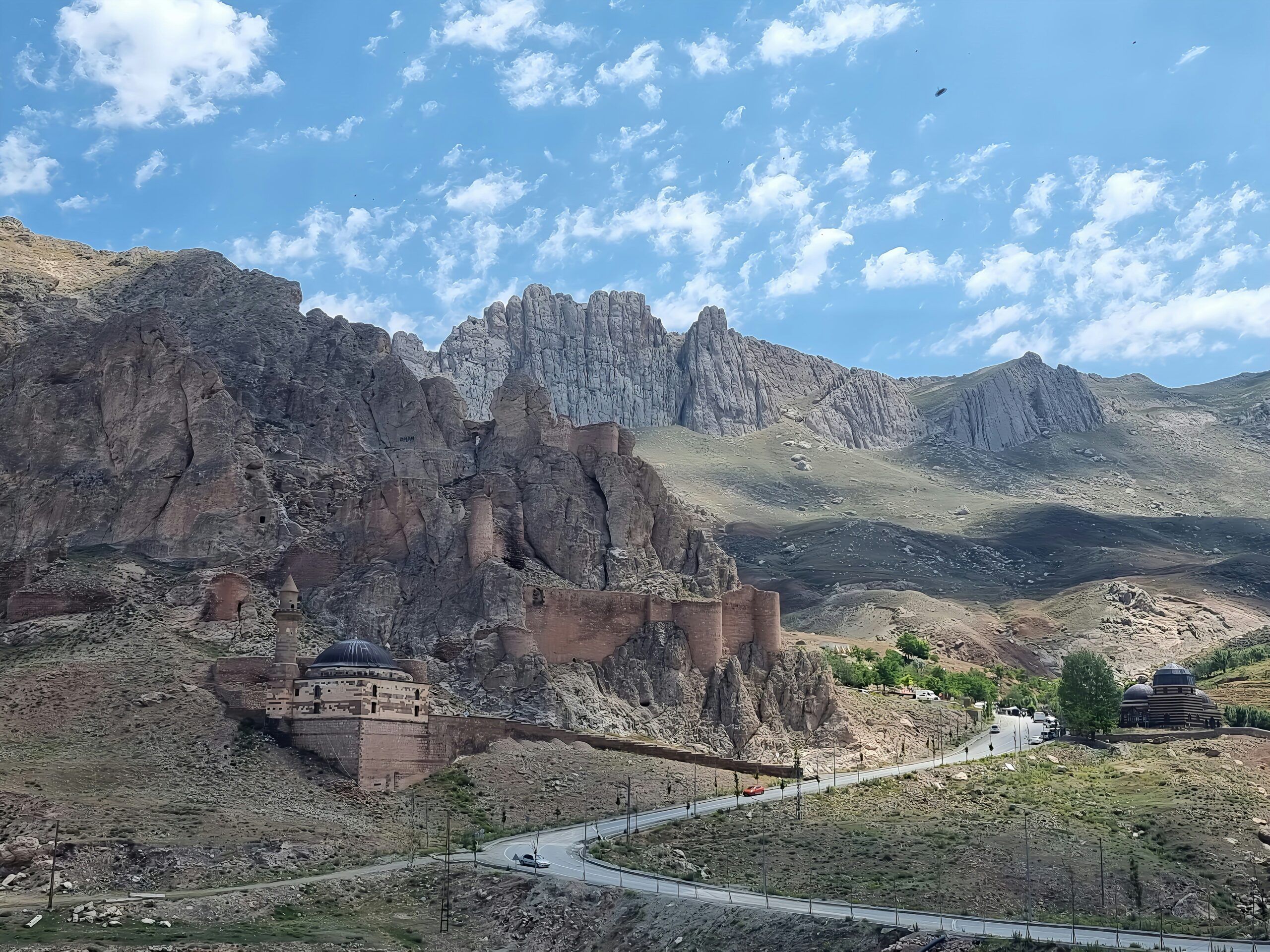 a scenic view of a mountain with a road going through it